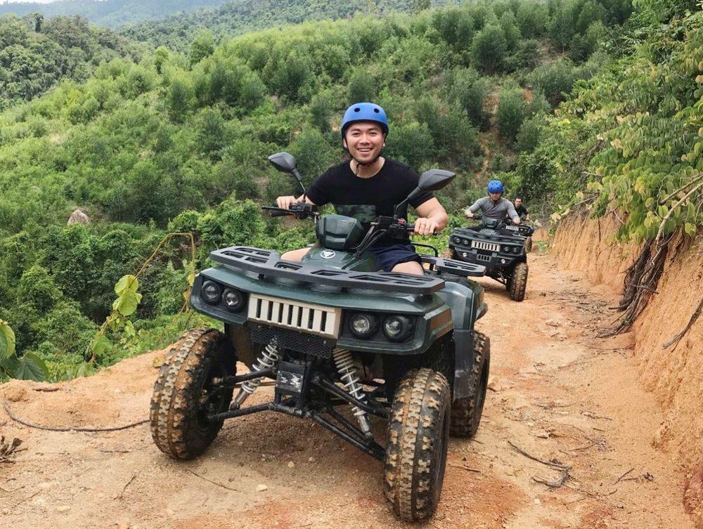 A quad bike on a mountain trail above a green valley